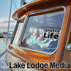 Shasta Life sticker on a wooden boat window; Lake Lodge Media text at bottom.