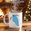 White mug with Lake Mohave map and compass design, splashing coffee.