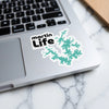 Sticker with "martin Life" text and teal lake outline on laptop.