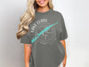 Gray t-shirt with white text "Lake Clark Alaska" and turquoise lake graphic on compass.