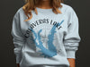 Light blue sweatshirt with Calaveras Lake Texas map and compass graphic.