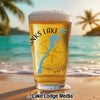 Beer glass on beach with "Thanks Lake" text, blue lake outline, and compass graphic.