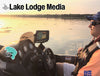 Man in boat with a fishing finder at sunset, text "Lake Lodge Media".
