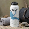 White water bottle with Granby map and compass design next to a rolled towel.