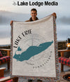 Man holding a woven blanket with a teal silhouette of Lake Erie and compass rose.