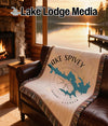 Blanket with Lake Spivey map and compass design on a sofa.