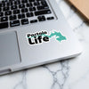 Pactola Life sticker with a turquoise lake outline on a laptop keyboard.