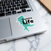 Turquoise "Quivira Life" sticker on a laptop keyboard with copyright text.