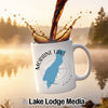 White mug with "Moraine Lake Alberta" design, coffee splashing into it.