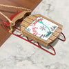 Wooden sled ornament with red runners, featuring "Merry Christmas" and "From Trinity Lake".