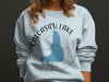 Light blue sweatshirt with Calcasieu Lake Louisiana map and compass graphic.