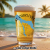 Glass of beer with Lake Charlevoix map and compass on a beach.