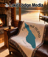 Woven throw on a leather chair with Catalina Island design and sunset lake view.