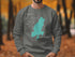 Grey sweatshirt with "Beautiful Lake Tiorati New York" text and compass rose graphic.