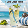 Glass with lime, mint, and ice, against a beach and sailboat backdrop.