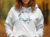 White hoodie with blue Lake Amistad Texas compass design and copyright text.
