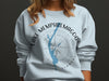 Light blue sweatshirt with Lake Memphremagog Vermont compass graphic.