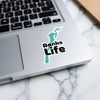 Aqua shape sticker with "Banks Life" text on a laptop keyboard.