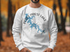 White sweatshirt with blue Percy Priest Lake map and compass graphic.