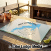 A rectangular glass cutting board featuring an Arcadia Lake map design on a wooden outdoor bar.