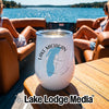 A white wine tumbler with a Lake Michigan design sits on a wooden boat table.
