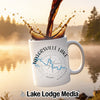 White mug with Taylorsville Lake logo and compass design, coffee pouring into it.