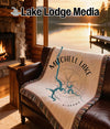 Woven blanket with Mitchell Lake Alabama map design on a leather sofa.