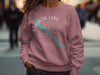 Pink sweatshirt with Maligne Lake Canada graphic and compass rose design.