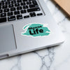 Sticker on laptop: "Monroe Life" in black and turquoise with copyright.