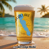 Glass of beer with "Vlas Lake" and a blue lake silhouette on a beach.