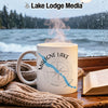 White mug with "Maligne Lake Canada" text and compass design near a lake.