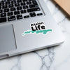 Atsion Life sticker on a laptop keyboard with a turquoise water outline.