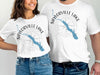 White t-shirts featuring a blue outline of Saylorville Lake and compass graphic.