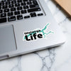 Watauga Life sticker with turquoise lake outline on a laptop.