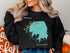 Black sweatshirt with teal Lake Hefner map and compass graphic.