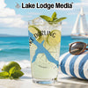 Tall glass of drink with lime and mint on beach with sailboat.