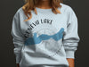Front of light blue sweatshirt with "Geneva Lake Wisconsin" and compass design.