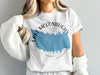 White t-shirt with blue Lake McConaughy map graphic and "Nebraska" text.