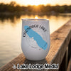 A white stemless tumbler with an Onondaga Lake map graphic rests on a wooden dock at sunset.