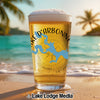 Glass of beer with Lake D'Arbonne map and compass on beach background.