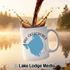 White mug with Lake Okeechobee map and compass, coffee splashing.