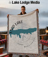 Man holding a blanket with map of Enid Lake Mississippi and compass design.