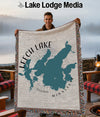 Man holding Leech Lake Minnesota map blanket with fringed edges.