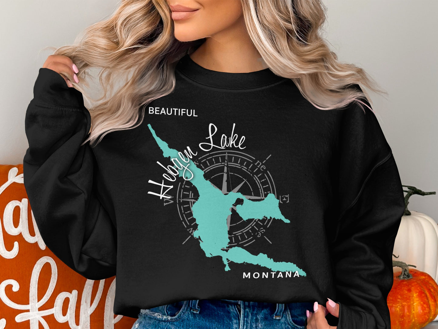 Black sweatshirt with turquoise map graphic and compass on chest.