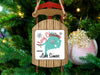 Sled-shaped ornament with "Merry Christmas from Lake Simcoe" text hangs on a Christmas tree.