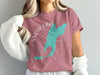 Pink t-shirt with turquoise Snow Lake Washington graphic and compass rose.