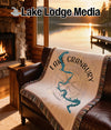 Woven blanket with Lake Granbury map design draped over a leather sofa.
