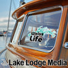Weiss Life sticker on a wooden boat window with "Lake Lodge Media" text.