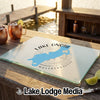 A glass cutting board featuring a blue map of Lake Onota, Massachusetts, on a wooden outdoor bar.