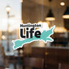 Huntington Life sticker, shaped like a lake, adhered to a window.